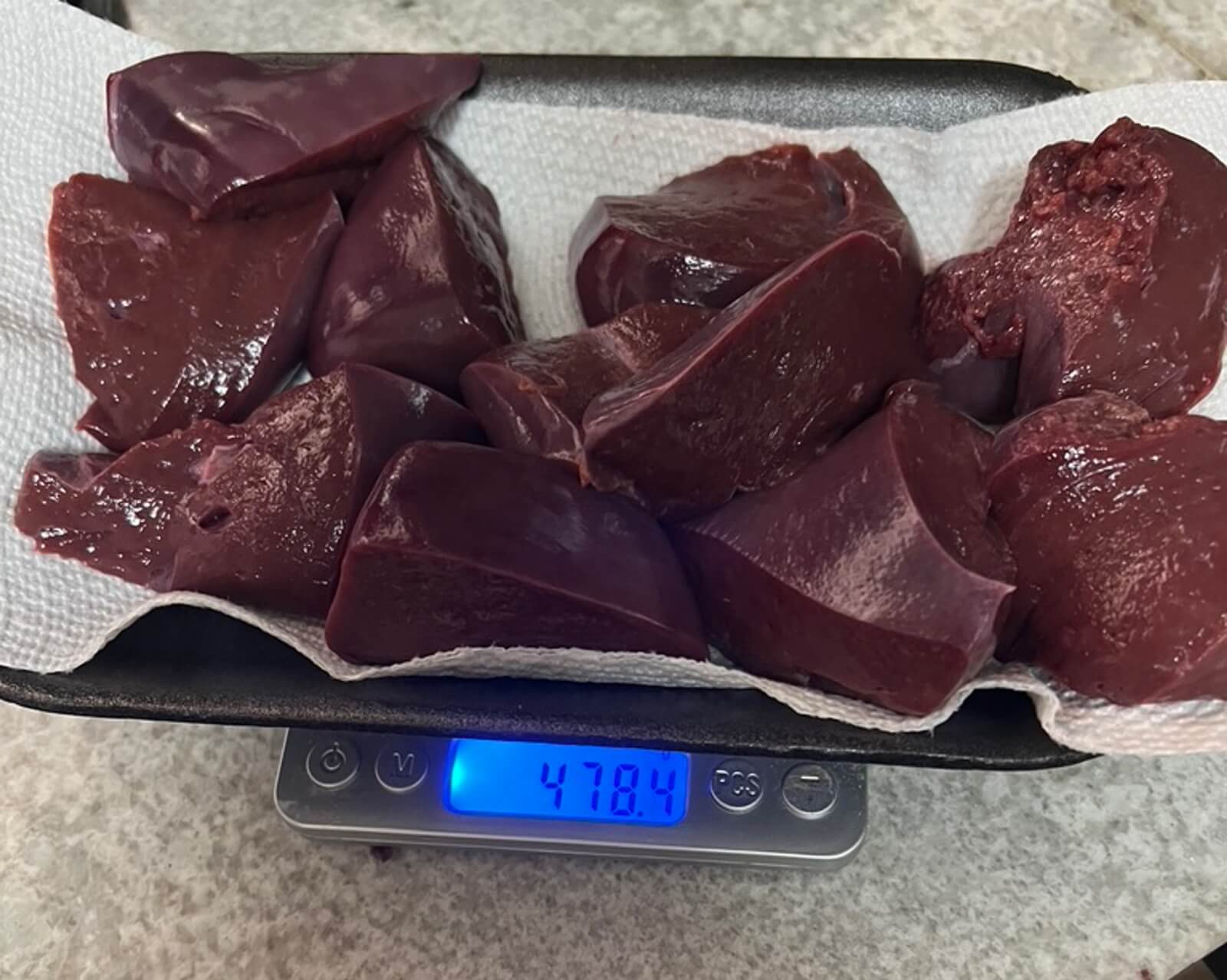 Raw beef liver cut into cubes, weighed on a digital scale showing 478.4 grams